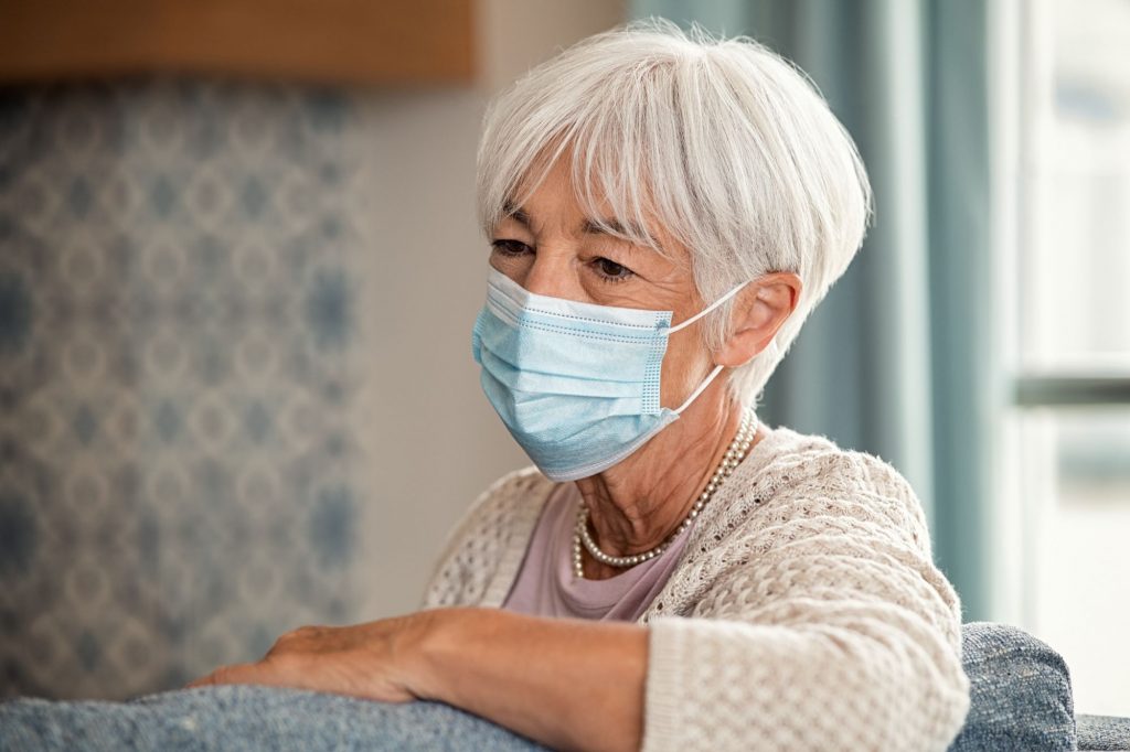 woman-on-couch-wearing-medical-mask