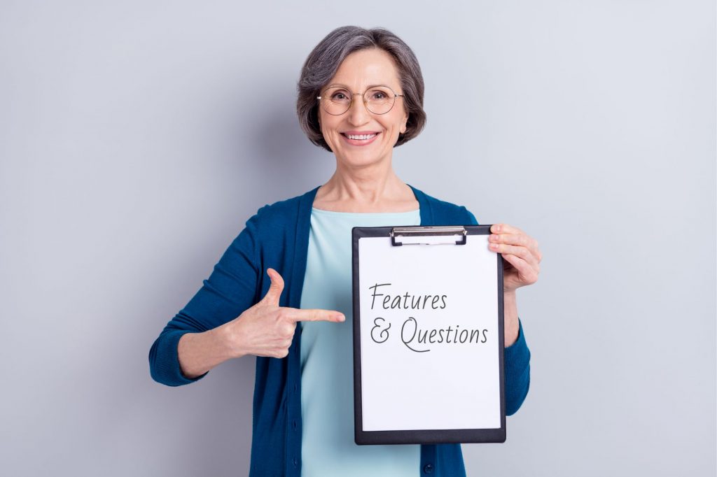 woman holding sign that says features and questions