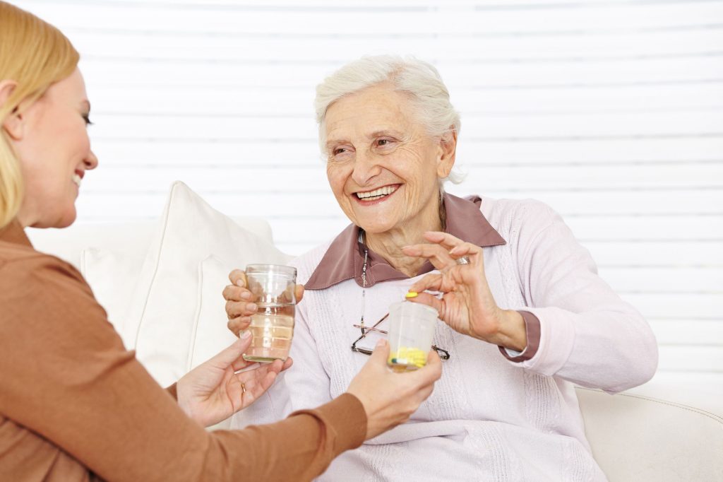 home caregiver distributing medication to a woman