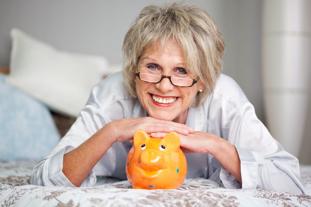 happy lady laying down with piggy bank