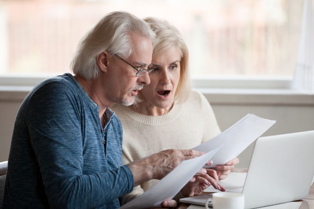 Shocked couple looking at a reverse mortgage