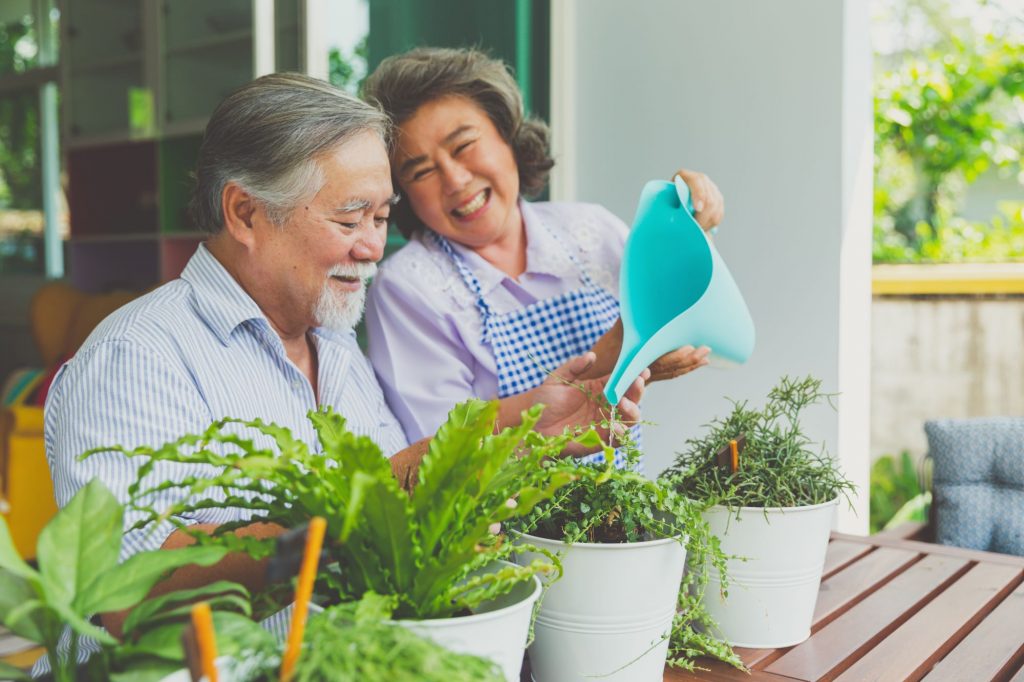 independent living couple watering plants