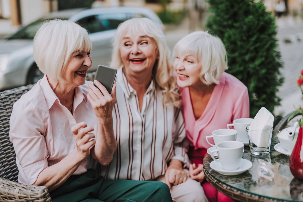 three senior women friends hanging out and laughing, shared housing friends