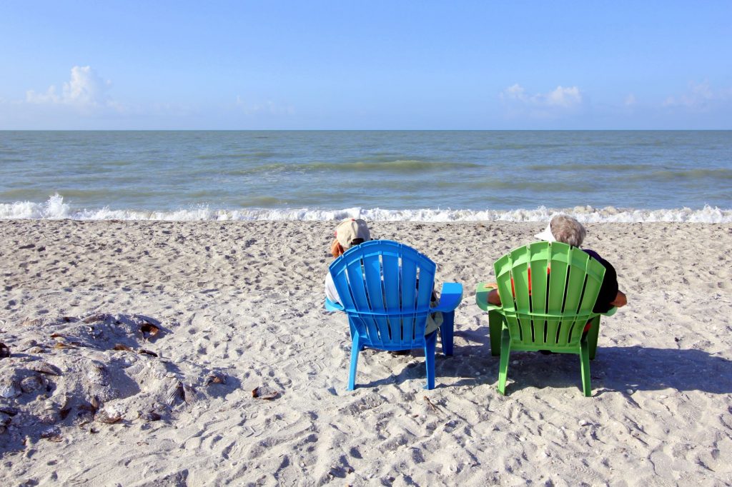 two retirees sitting on the beach