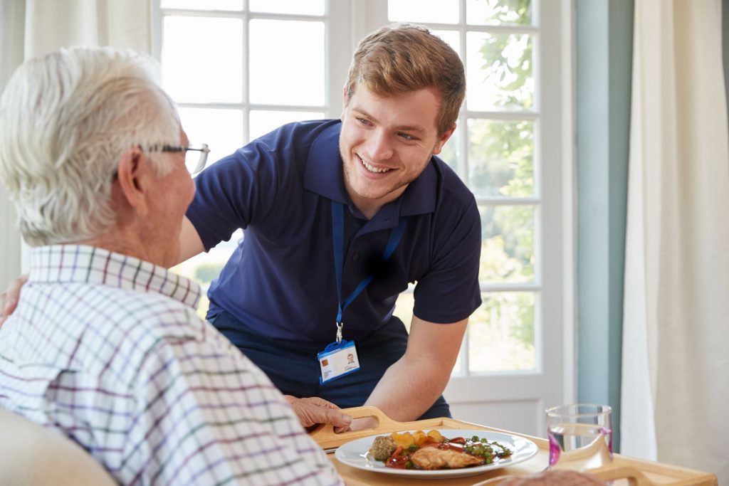 Home care worker assisting senior gentleman. Does Medicare Cover Home Health Care?