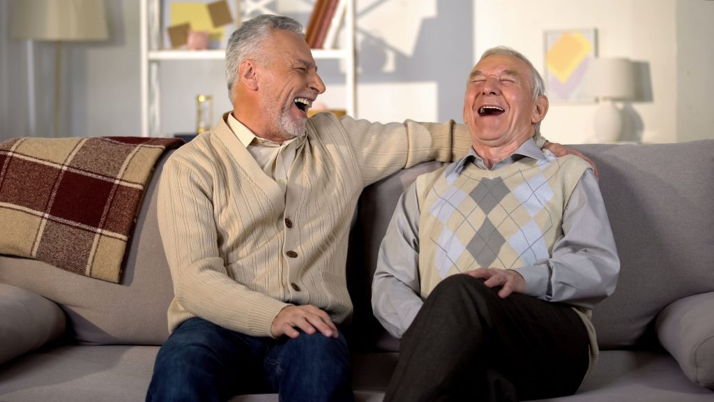 senior friends laughing on couch about  14 ways retirees can make extra money
