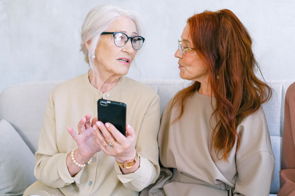 two senior women looking at a cell phone together