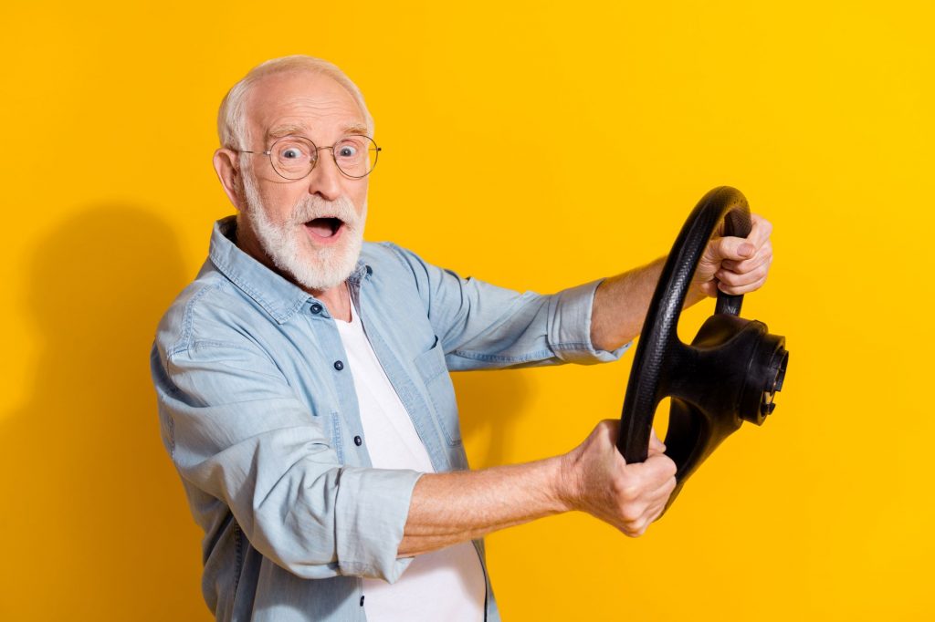 senior man holding a steering wheel How Older Drivers Can Save on Auto Insurance 