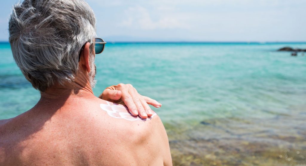 Is Skin Cancer Hereditary? Senior putting on sunscreen
