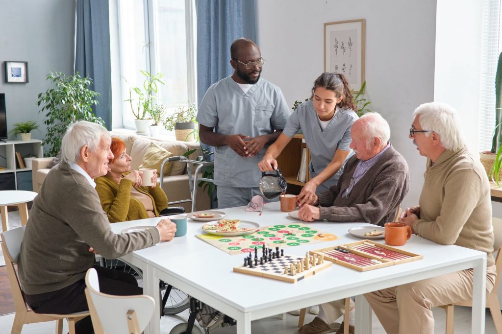 Nurses interacting with seniors at a nursing home activity hour.