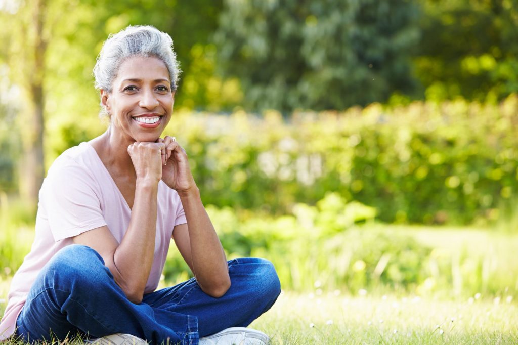 African American retired woman sitting outside smiling