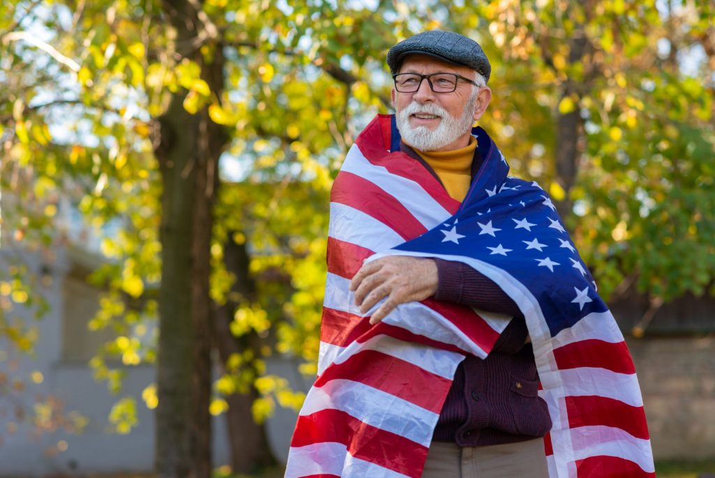 senior veteran wearing an American flag