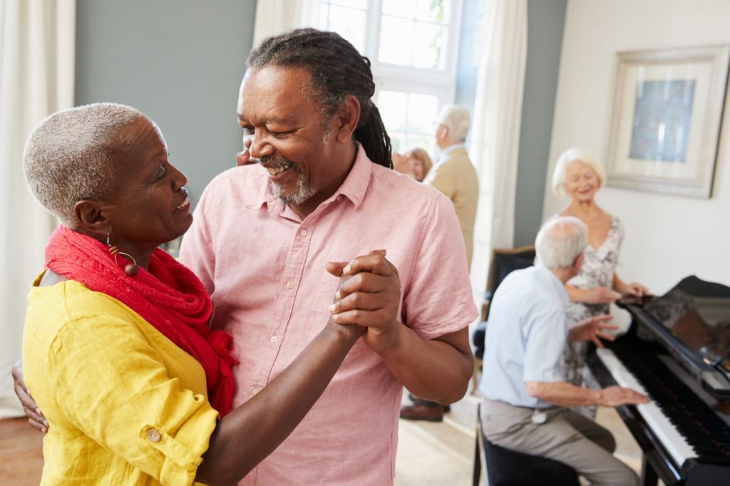 African-American couple dancing together at a senior citizen center.