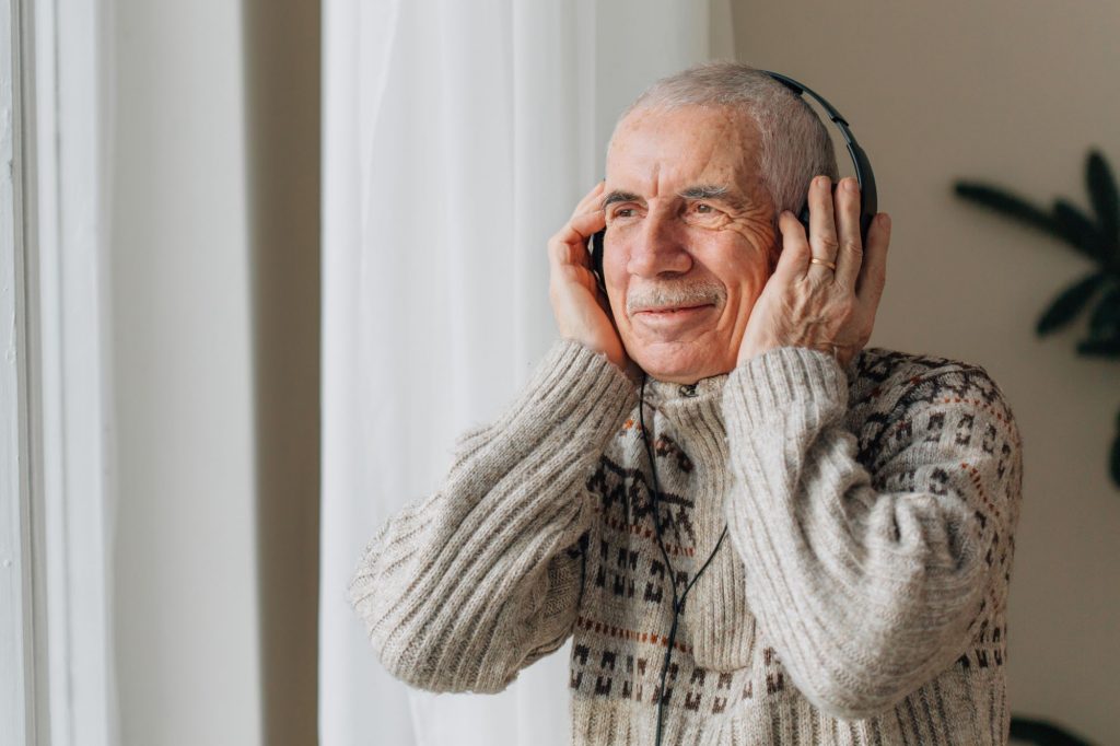 Elderly man listening to music and dancing.