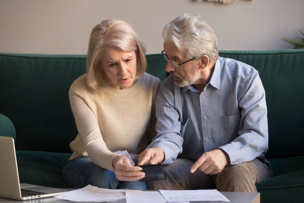 Senior couple calculating finances and pondering Social Security benefits. 