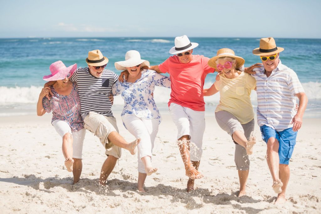 Seniors dancing on the beach in retirement.