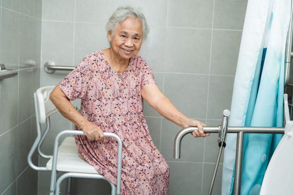 Older lady sitting in shower seat.
