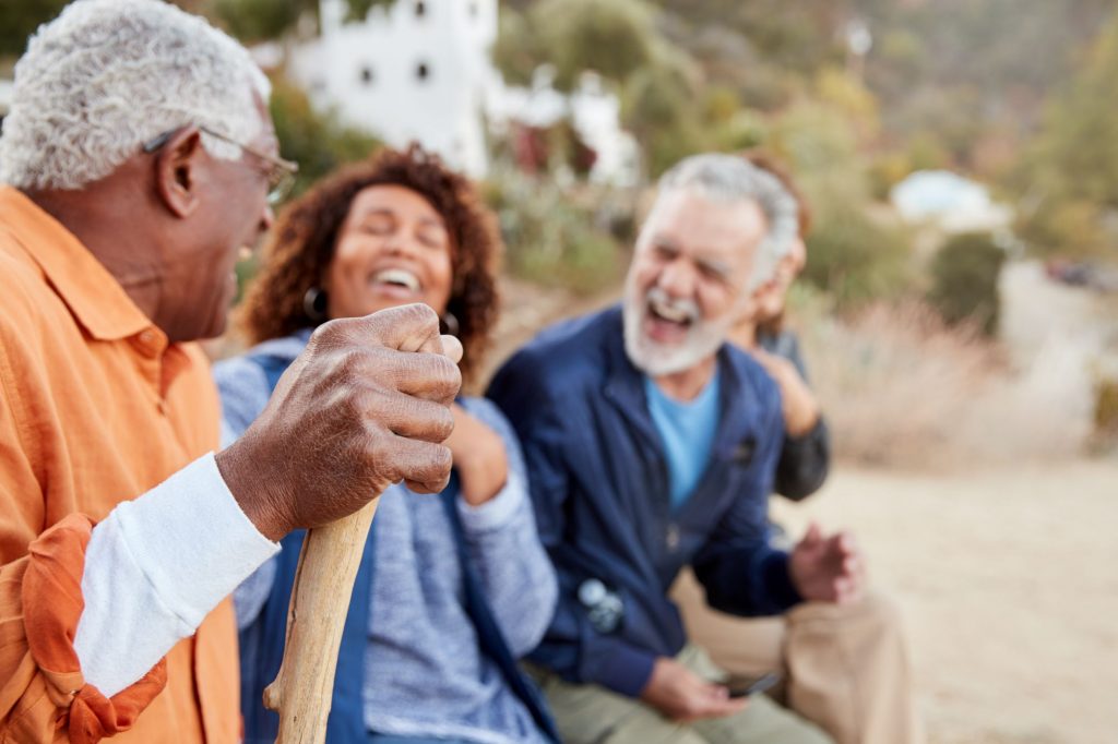 group of social retirees laughing at the beach