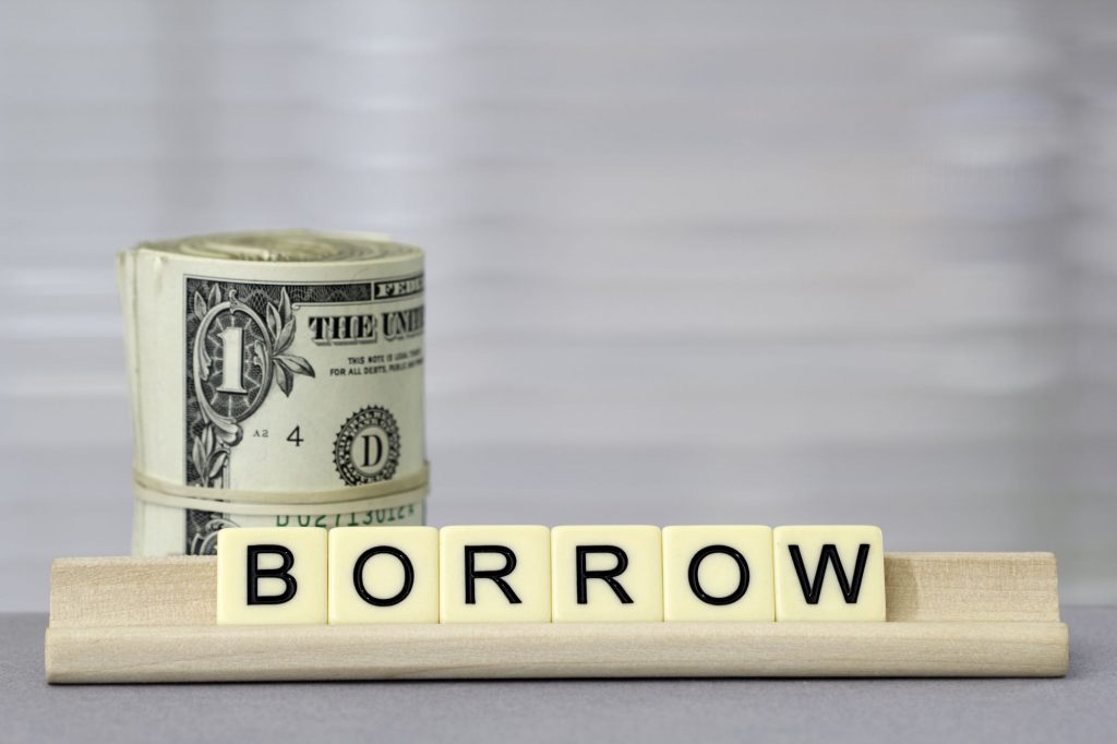 borrow spelled on tiles with cash in background