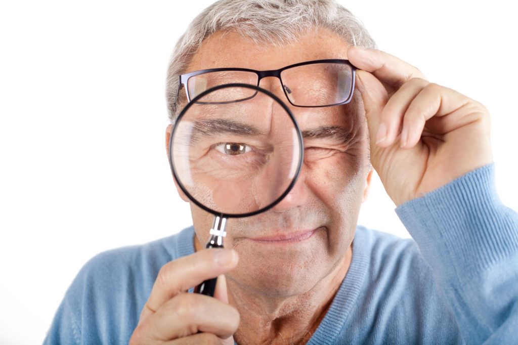 man looking through a magnifying glass