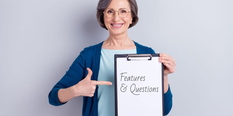 woman holding sign that says features and questions