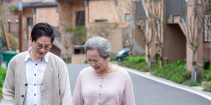elderly couple walking down the street in a ccrc development