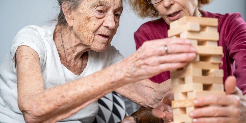 home caregiver playing jenga with woman