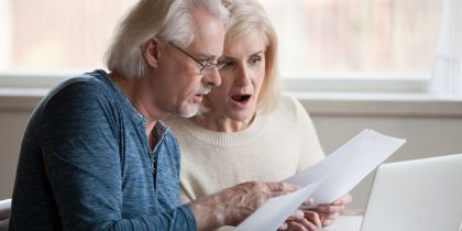 Shocked couple looking at a reverse mortgage