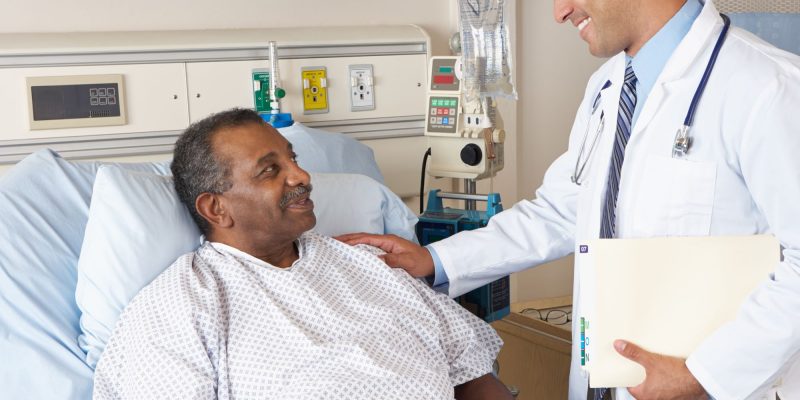 doctor and patient in hospital bed, smiling and talking