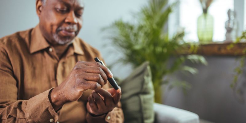 African American man checking glucose