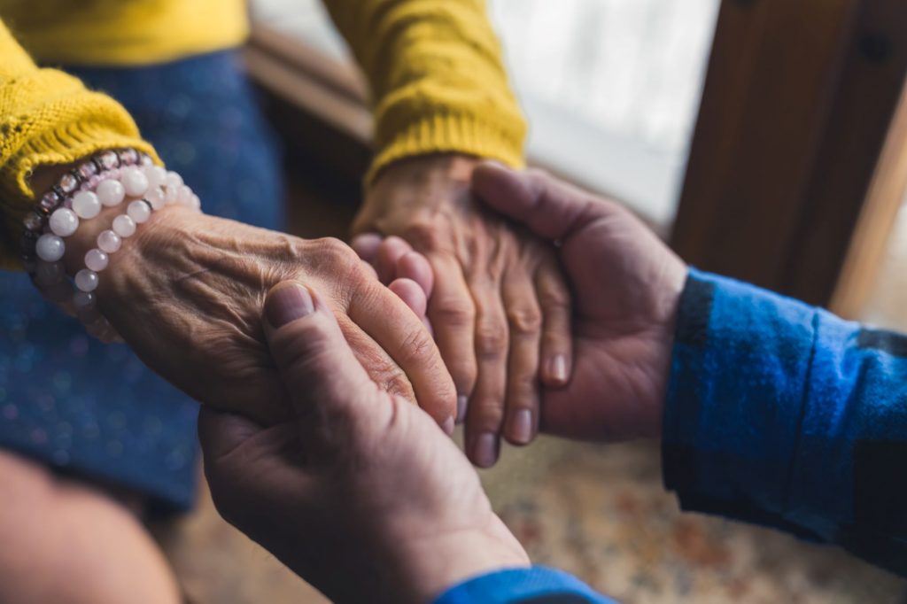 hands holding, one pair is aged, the other is younger