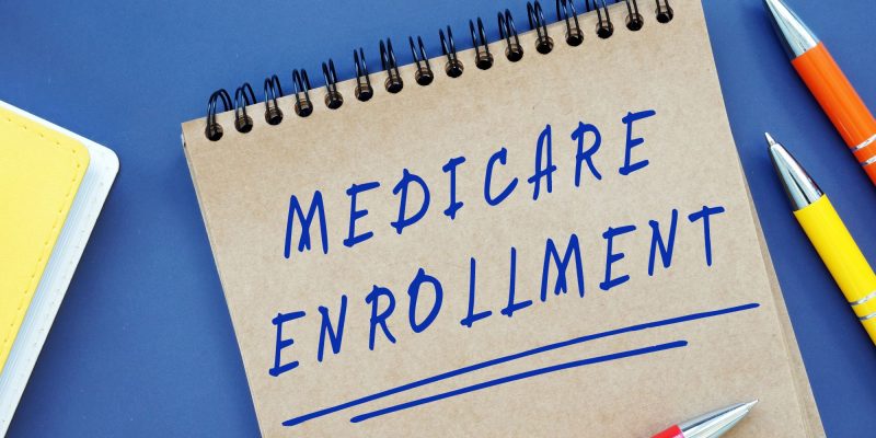 Medicare enrollment written on a notepad with pen