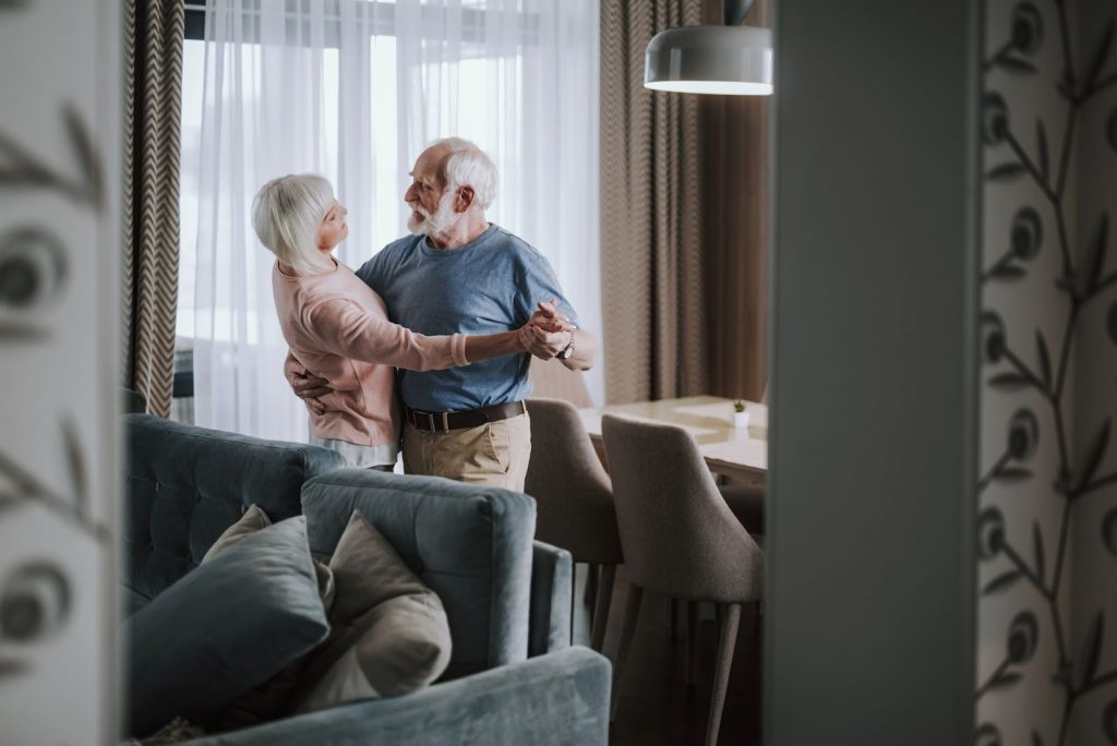 a senior man and woman dancing in their 55+ senior apartment