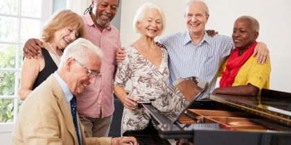 seniors gathered around a piano