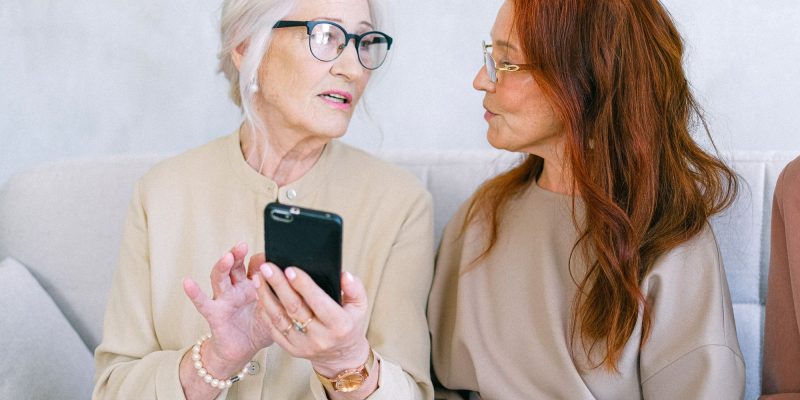 two senior women looking at a cell phone together