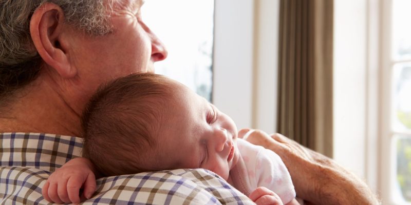 grandfather and newborn baby hugging