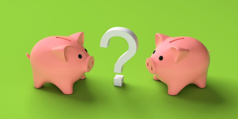 two piggy banks and a question mark on a green background