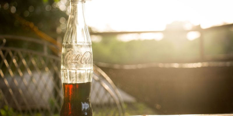 Half-empty bottle of coke in the sunlight