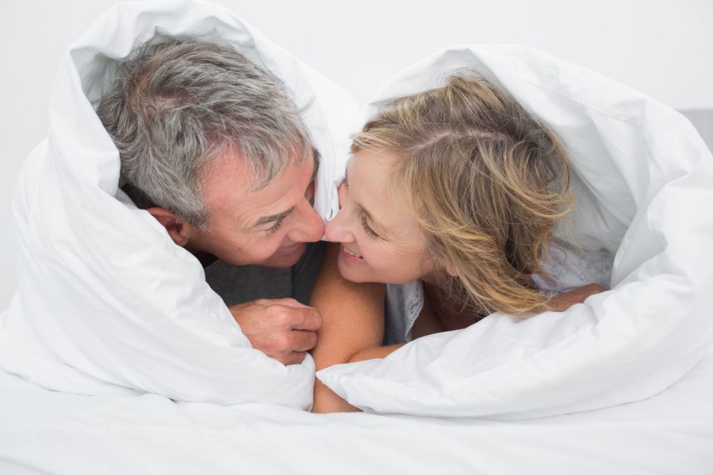 happy boomer couple in bed