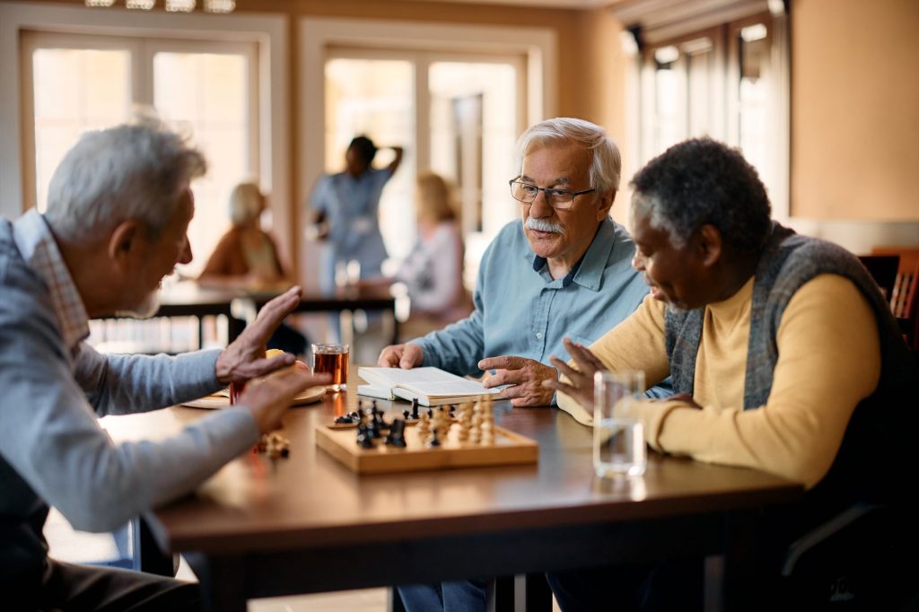 Elderly gentleman playing chess at an adult day care center.