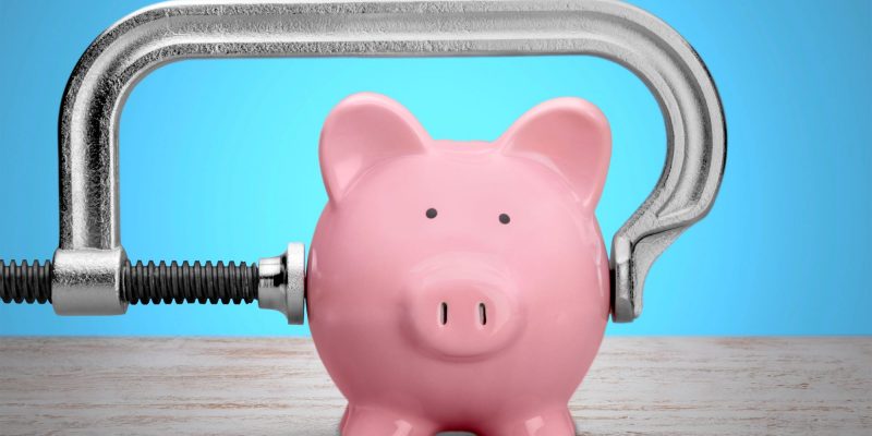 piggy bank in a vice grip