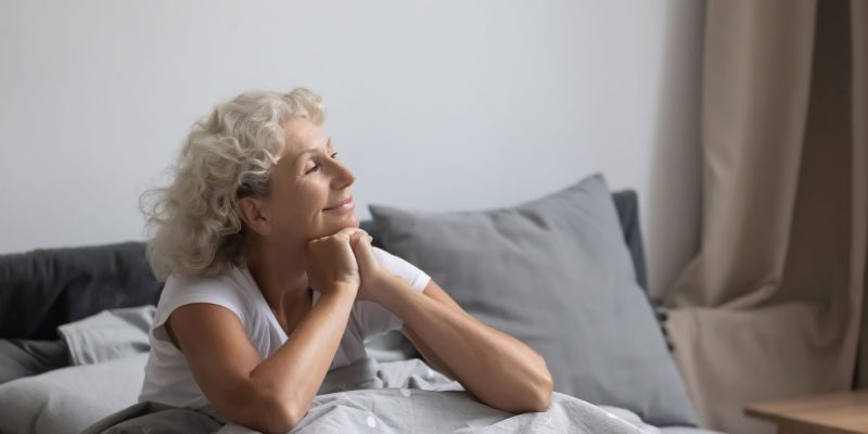woman alone and happy in bed