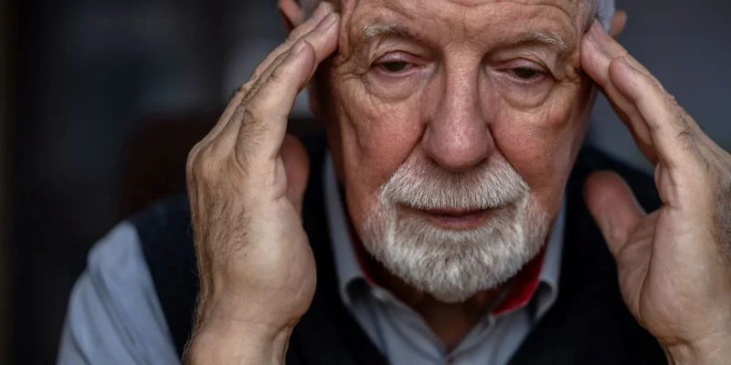 close up of a senior man with white hair and white beard, hands on head, confused, depressed, possibly dementia or alzheimer's