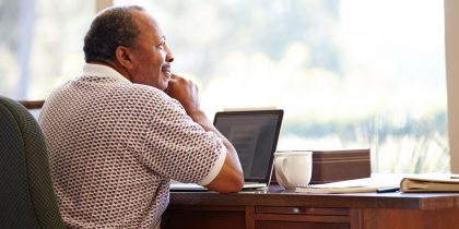 African American over 65 man sitting at desk working