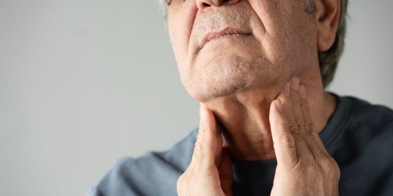 man examining own thyroid