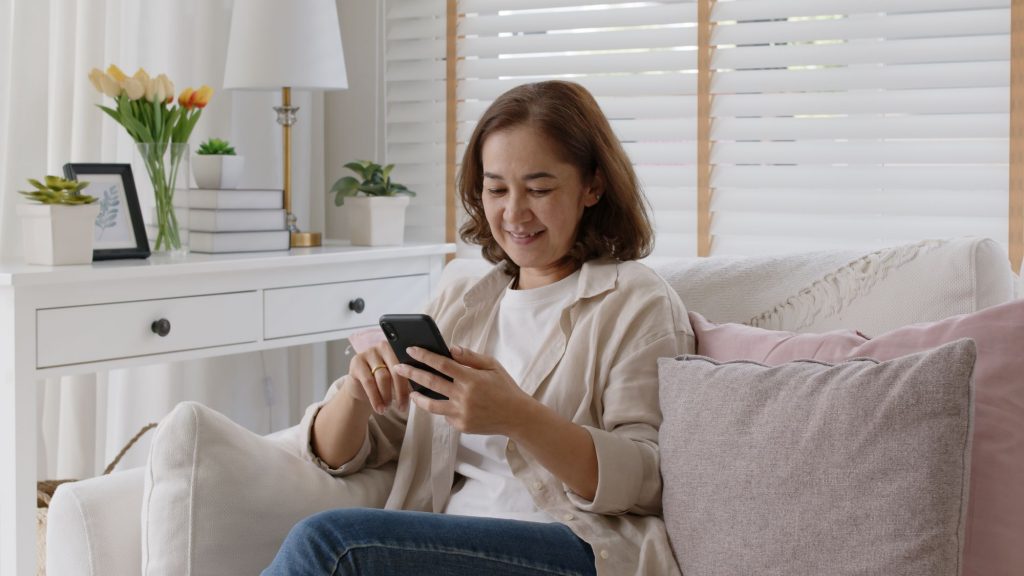 woman sitting on couch texting