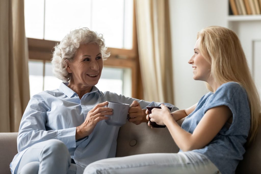 older woman and younger woman sitting on the couch talking