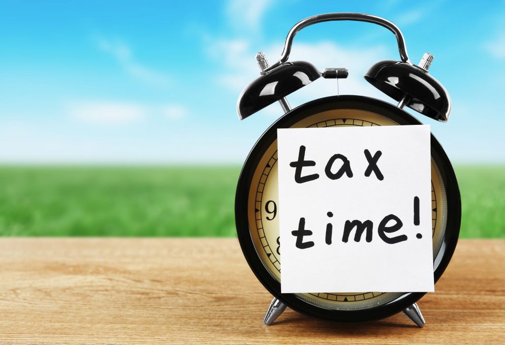 sticky note over clock face that says "tax time!"