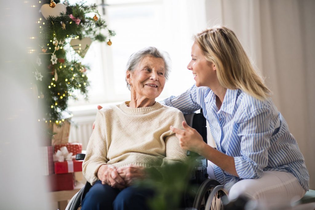 senior in wheelchair near Christmas tree