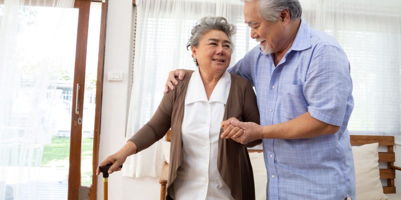 Asain retired couple walking, woman walking with cane